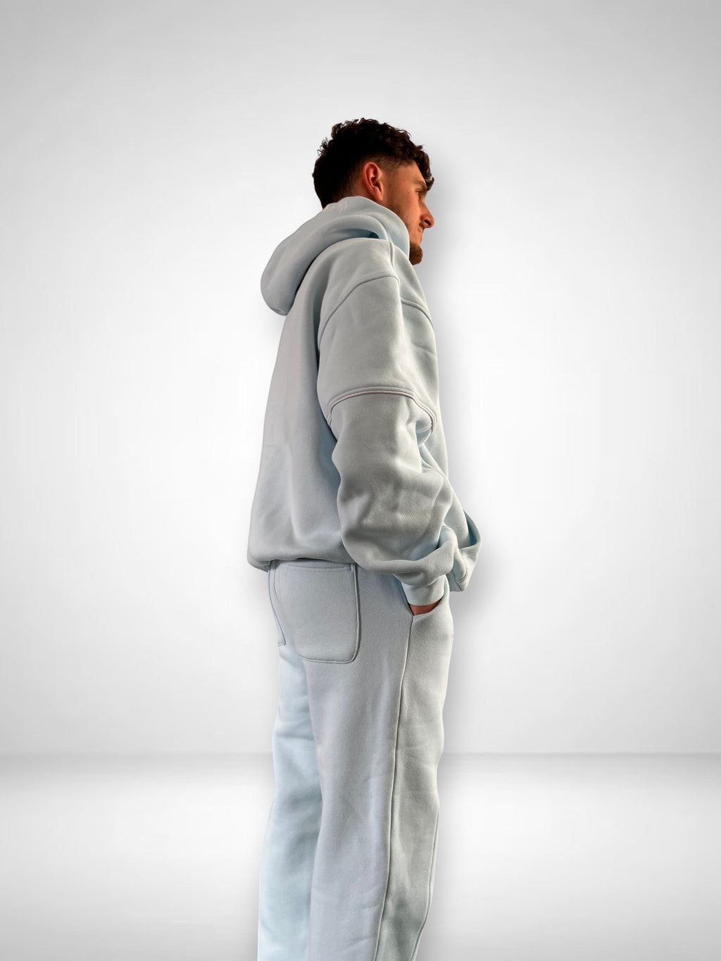 SLAYZ light blue oversized cotton blend jogging suit with contrast stitching and embroidered logo. Model wears hoodie and matching pants.