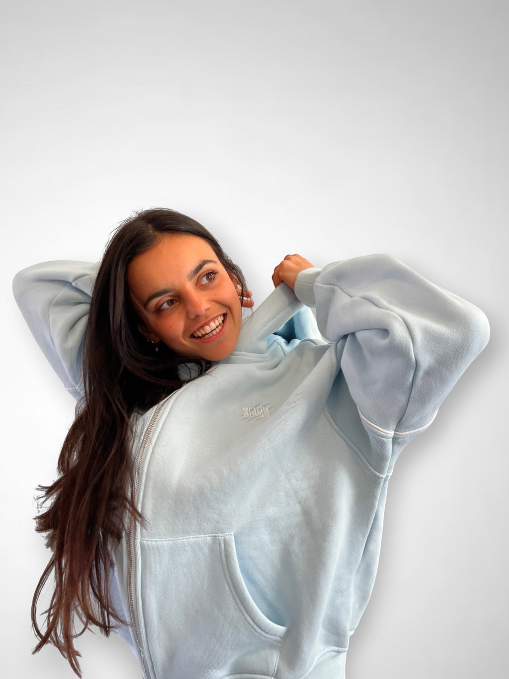 SLAYZ light blue cotton blend zip-up hoodie with pockets and hood. Model wears it casually.