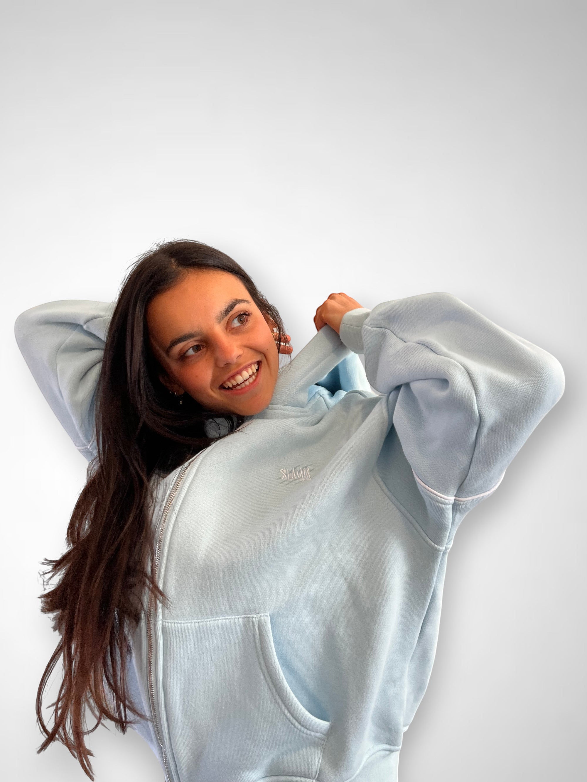 SLAYZ light blue cotton blend zip-up hoodie with pockets and hood. Model wears it casually.